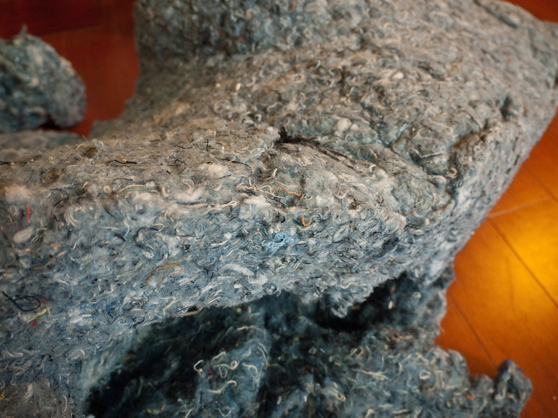 Image showing insulation material made from recycled denim. The material is soft and bulky and pale blue in colour with some multicoloured strands of material mixed in.