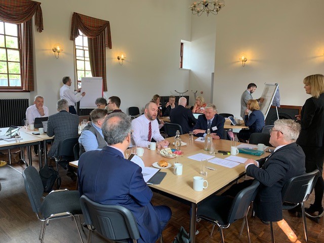 A photo showing Committee members and stakeholders discussing the National Performance Framework at the Committee's event in Dundee on 10 May 2022.